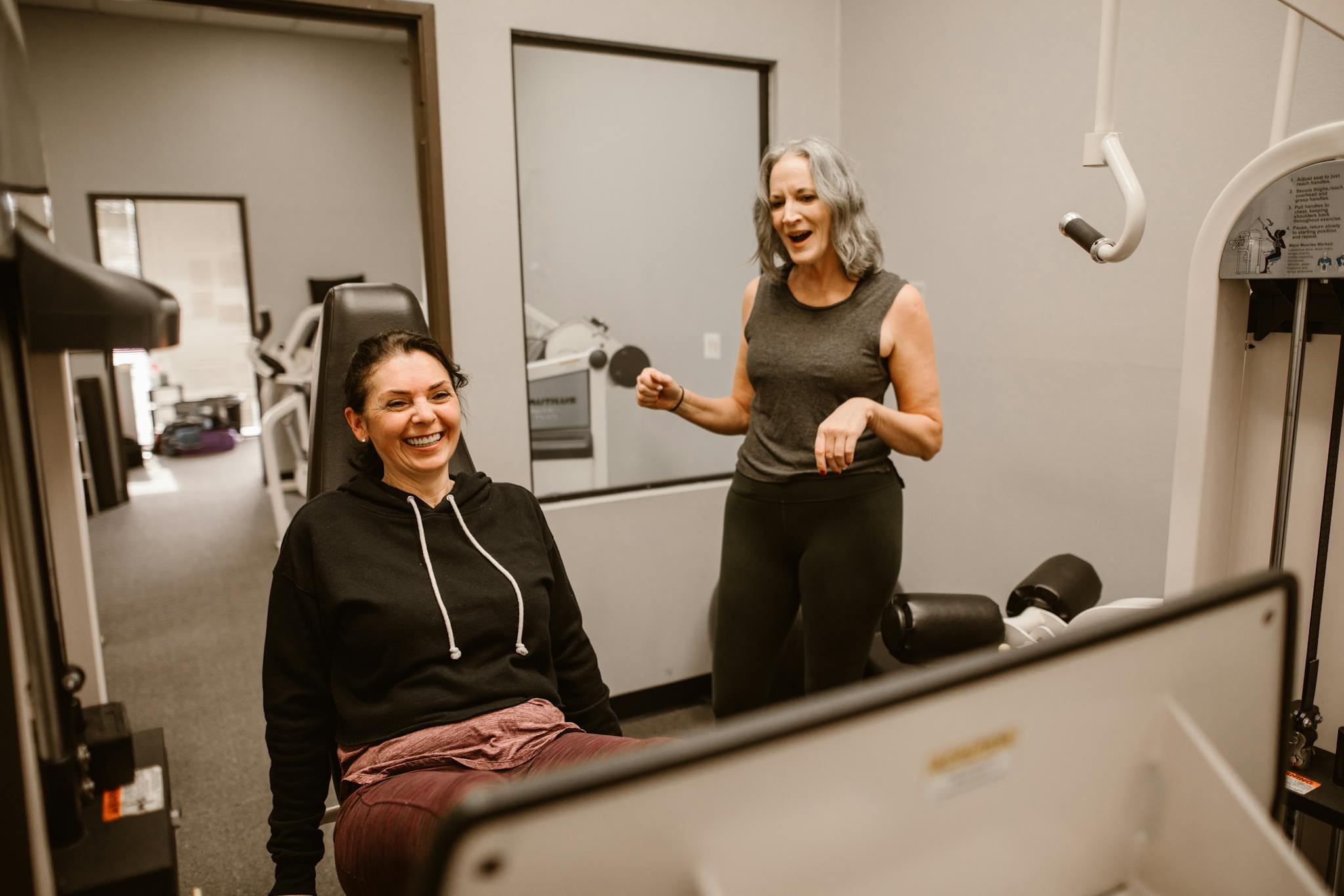 Two women enjoying a workout session indoors, promoting health and wellness.
