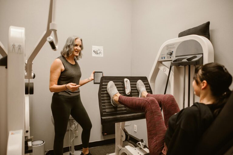 Two women exercising indoors, focusing on health and wellness at a gym.
